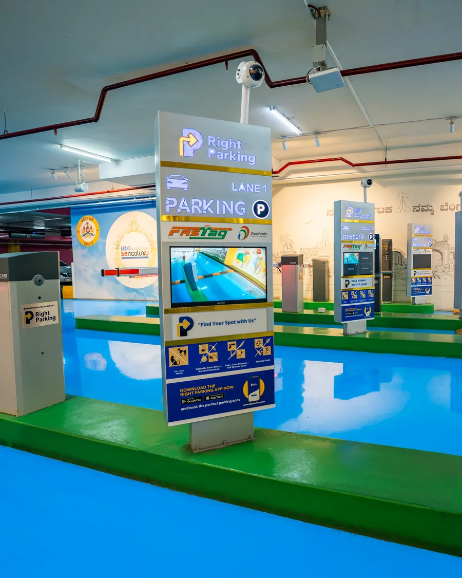 Right Parking at Freedom Park — underground FASTag entry lane with ticket kiosks, CCTV and a colour-coded painted deck